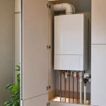 Газовый котел в кухонном шкафу с доступом к трубам и вентиляцией